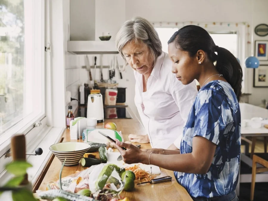A home care client preparing food with a family member in the kitchen on a home in London