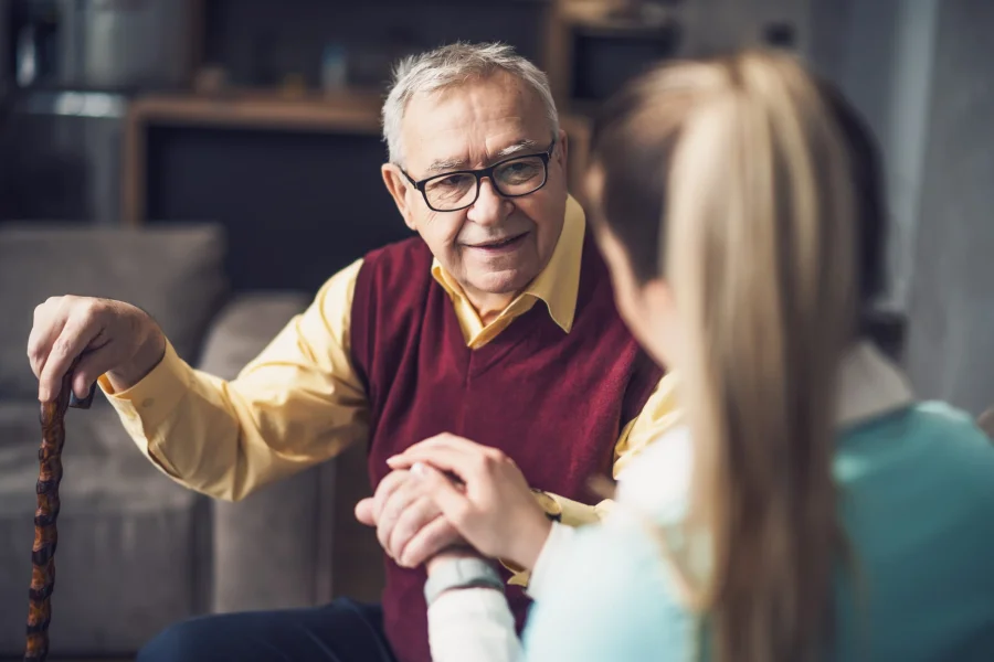 Home nurse visiting senior man to check his health. Professional caregiver is assisting old man at his home.
