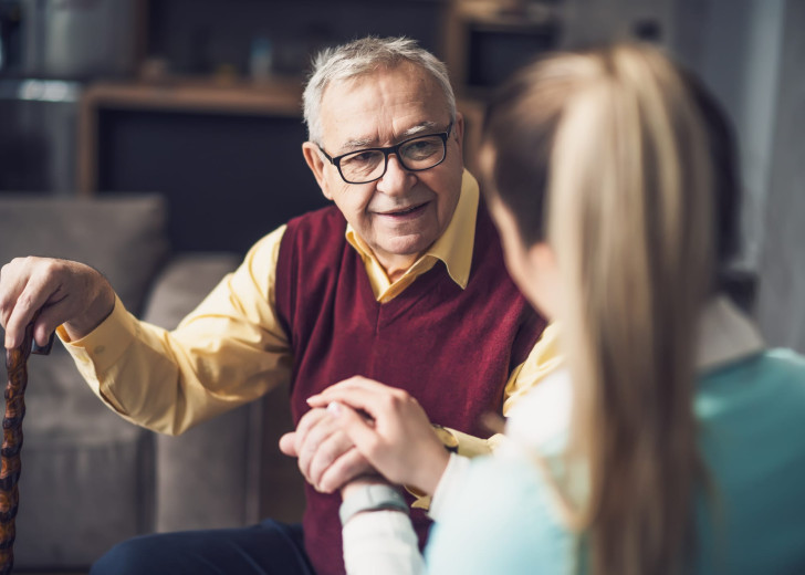 Home nurse visiting senior man to check his health. Professional caregiver is assisting old man at his home.