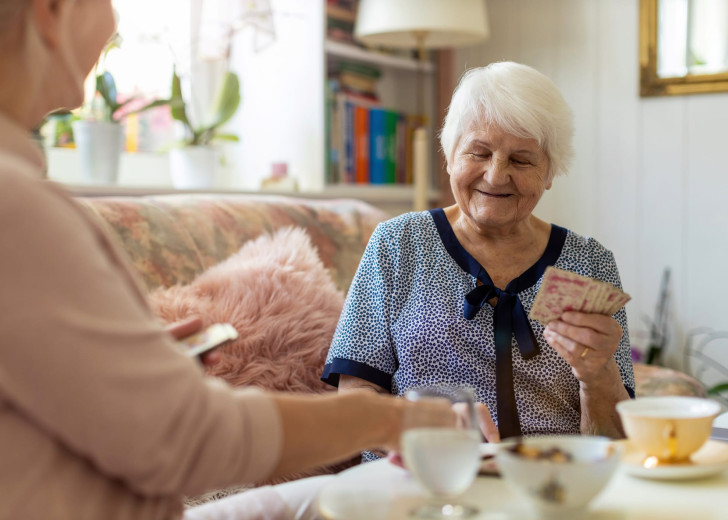 Senior woman and her adult daughter playing cards at home
