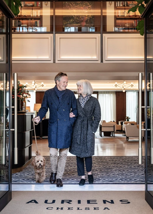 Man and woman walking dog through lobby of Auriens Chelsea
